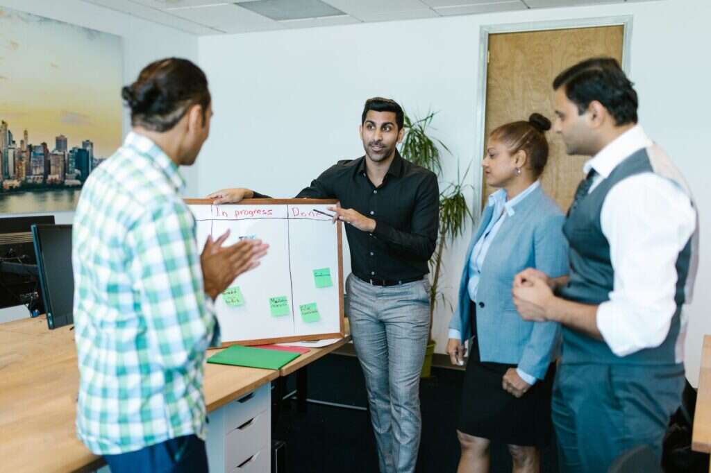 Team discussing a project around a board in an office
